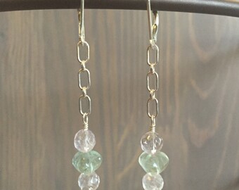 May include: Silver chain earrings with three gemstone beads. The beads are a light pink, a light green, and another light pink.