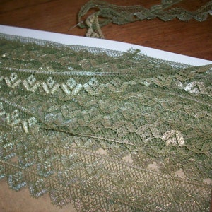 Puede incluir: Borde de encaje verde y dorado con un patr&oacute;n delicado. El encaje es suave y brillante, perfecto para agregar un toque de elegancia a cualquier proyecto.