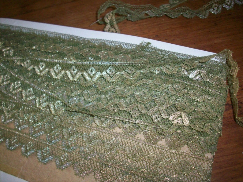 Puede incluir: Borde de encaje verde y dorado con un patr&oacute;n delicado. El encaje es suave y brillante, perfecto para agregar un toque de elegancia a cualquier proyecto.