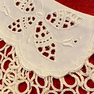 Puede incluir: Collar de encaje blanco con un delicado dise&ntilde;o de mariposa y un borde festoneado. El collar est&aacute; adornado con una franja de peque&ntilde;os bucles.