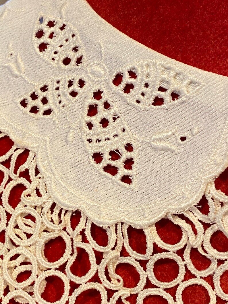 Puede incluir: Collar de encaje blanco con un delicado dise&ntilde;o de mariposa y un borde festoneado. El collar est&aacute; adornado con una franja de peque&ntilde;os bucles.