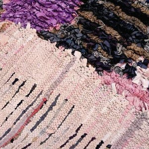Puede incluir: Un primer plano de una alfombra colorida tejida a mano con una variedad de texturas y patrones. La alfombra est&aacute; hecha de materiales reciclados y tiene un estilo &uacute;nico y bohemio.