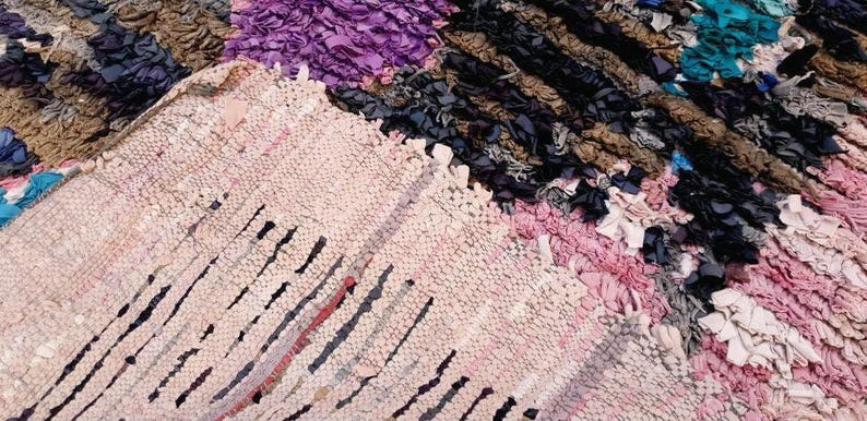 Puede incluir: Un primer plano de una alfombra colorida tejida a mano con una variedad de texturas y patrones. La alfombra est&aacute; hecha de materiales reciclados y tiene un estilo &uacute;nico y bohemio.