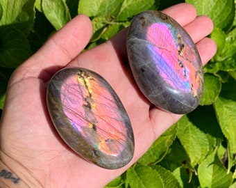 Purple labradorite palm stone with imperfections, tiny chip