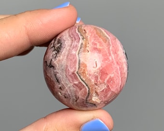 Rhodochrosite sphere with stand 35mm with hematite inclusions