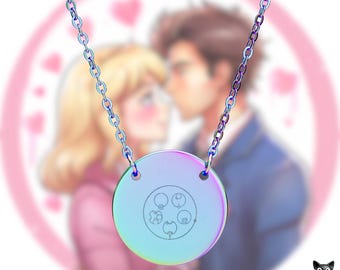 May include: A rainbow-colored Doctor Who pendant necklace with a circular pendant. The pendant features a design with four circles and a symbol. The necklace chain is also rainbow-colored. The Doctor Who logo is visible at the top.