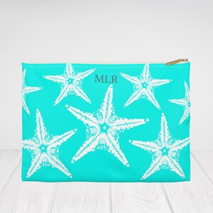 May include: A turquoise zippered pouch with a white starfish pattern and the monogram "MLR" in the centre.