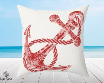 May include: Red anchor with rope design on a white pillow. The anchor is a nautical symbol of hope and strength.