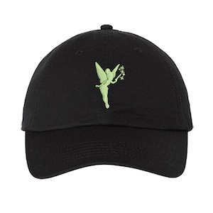 May include: A black baseball cap featuring an embroidered light green fairy silhouette on the front panel. The fairy is depicted in profile with wings extended and holding a small wand with star-shaped sparkles at the tip of the wand.