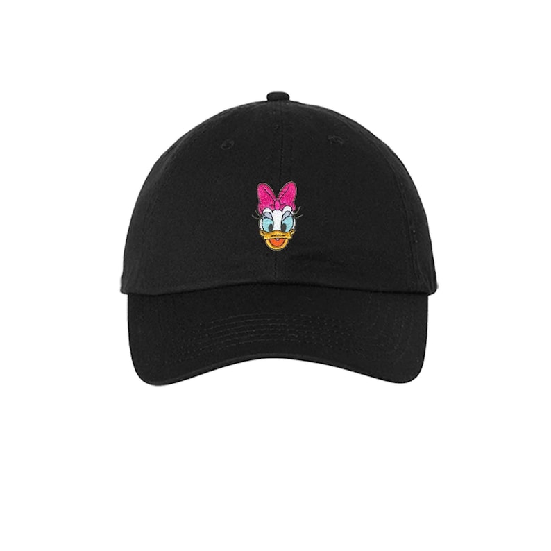 Op de afbeelding: Een zwarte baseballpet met een geborduurd beeld van Daisy Duck. Daisy Duck draagt een roze strik en heeft een gele snavel.