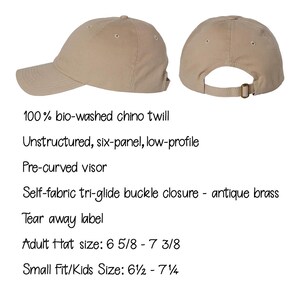 May include: A beige six-panel baseball cap made of 100% bio-washed chino twill. It features an unstructured, low-profile design with a pre-curved visor and an antique brass self-fabric tri-glide buckle closure. Includes a tear away label.