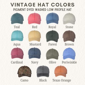 May include: A collection of fifteen pigment dyed washed low profile hats arranged in a grid. The colors include teal, red, royal, stone, aqua, mustard, forest, brown, cardinal, navy, olive, periwinkle, camo, black, and texas orange.