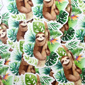 May include: A collection of watercolor sloth stickers with green tropical leaves and a bright orange flower. The sloths are brown and are depicted hanging from a tree branch.