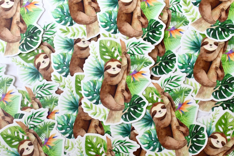 May include: A collection of watercolor sloth stickers with green tropical leaves and a bright orange flower. The sloths are brown and are depicted hanging from a tree branch.