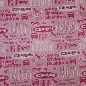 May include: Pink fabric with a repeating pattern of text and graphics from the movie "Clueless." The design includes phrases like "As If," "Buggin'," and "Clueless," along with images of cars, shoes, and stars.