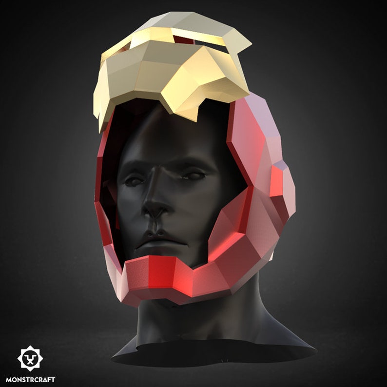 May include: A red and gold helmet with a geometric design. The helmet is made of paper and is designed to be worn as a costume.