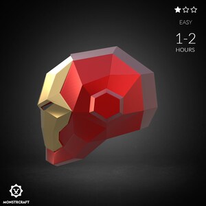 May include: A red and gold papercraft model of a helmet, resembling the Iron Man character from Marvel comics. The model is made of folded paper and has a geometric design.