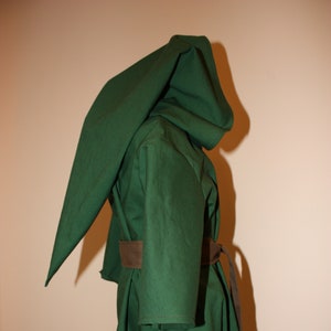 May include: A green hooded cloak with a brown belt. The cloak is made of a thick fabric and has a long, flowing hood.