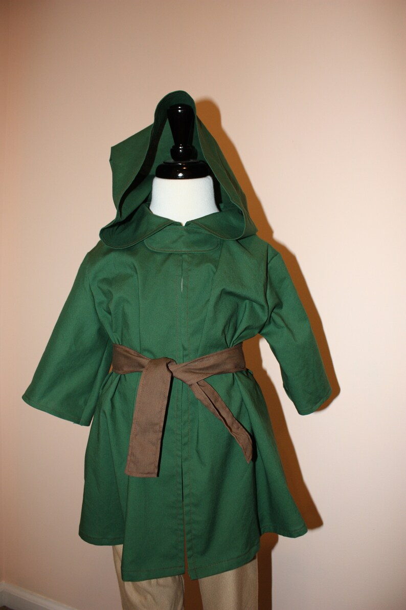 May include: A green hooded cloak with a brown belt. The cloak is made of a soft, comfortable fabric and has a relaxed fit.