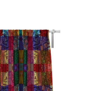 May include: A colorful patchwork curtain with a variety of colors and patterns, including red, green, blue, and yellow. The curtain is hung on a white curtain rod.