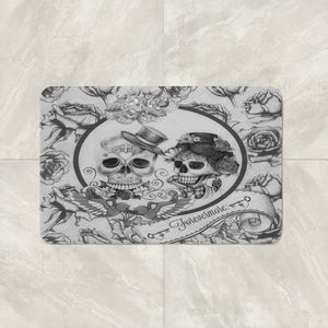 May include: A black and white bath mat with a floral design and two sugar skulls with the text "Forevermore."