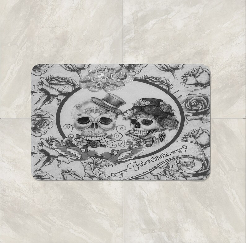 May include: A black and white bath mat with a floral design and two sugar skulls with the text "Forevermore."