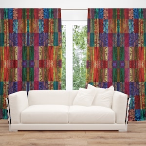 May include: A pair of colorful curtains with a patchwork design featuring red, orange, yellow, green, blue, and purple hues. The curtains are hung in a living room with a white sofa in front of a window.