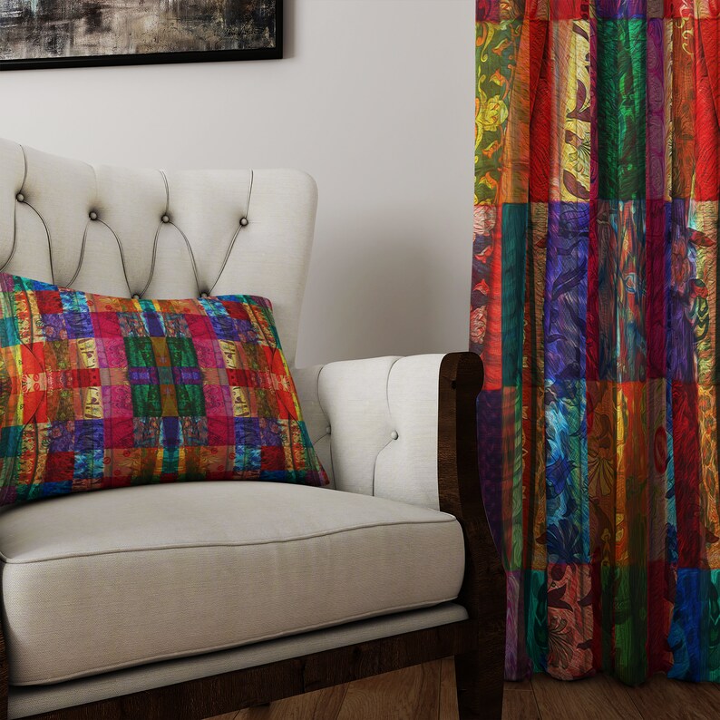 May include: A white armchair with a colorful patterned pillow. The armchair is in front of a colorful patterned curtain.