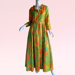 May include: A long, green, orange, and pink brocade dress with a ruffled collar and long sleeves. The dress has a button-up front and a full skirt.