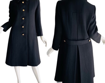 May include: A black wool coat with a collar and gold buttons. The coat has a fitted bodice and a flared skirt. The coat is shown from the front and back.