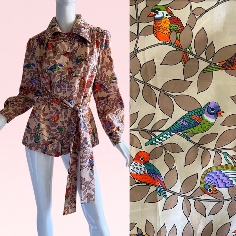 May include: A long-sleeved blouse with a brown background and a colorful bird print. The blouse has a collar and a tie belt.