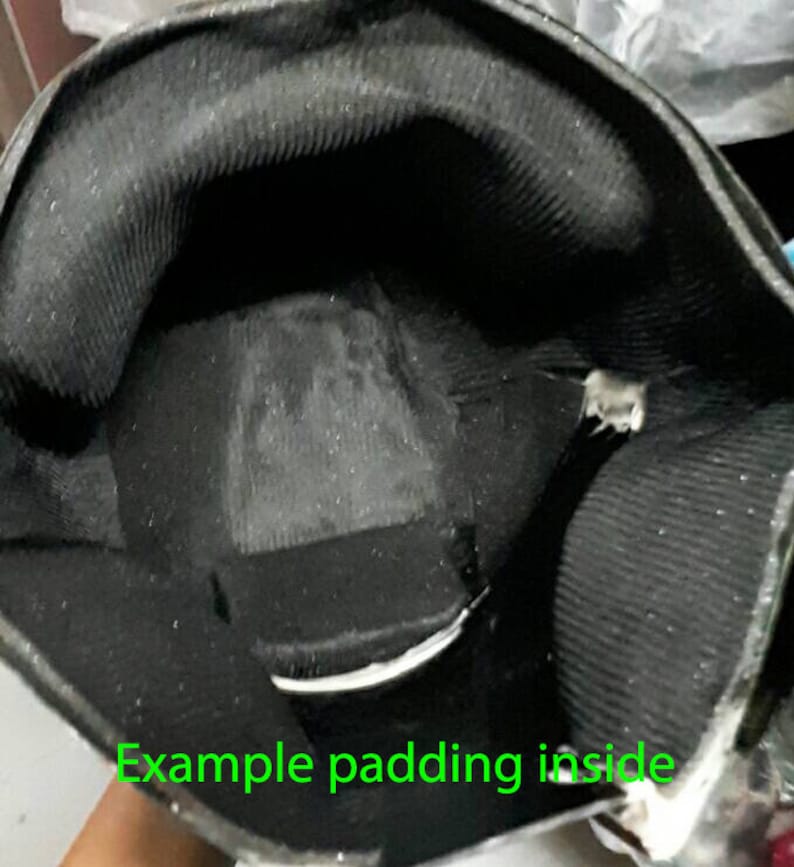 May include: Close-up of the inside of a black helmet with gray padding. The padding is designed to protect the wearer's head.