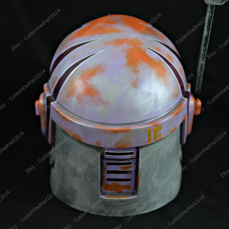 May include: A purple and orange painted helmet with a weathered look. The helmet has a raised number "16" on the side.