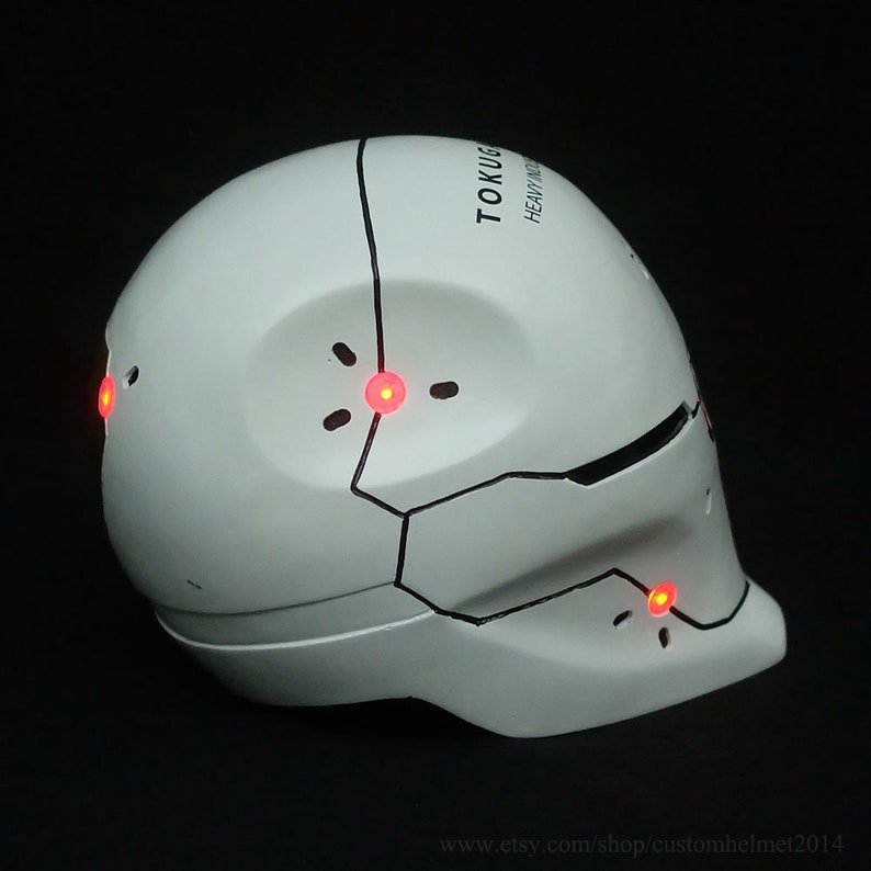May include: White helmet with black detailing and red LED lights. The helmet has the text "TOKU-G HEAVY INDUS" on the top.