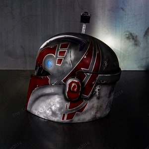 May include: A red, white, and gray helmet with a blue and purple design. The helmet has a weathered look and is made of plastic.