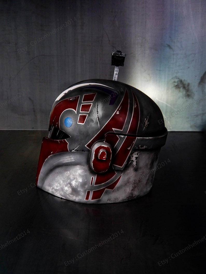 May include: A red, white, and gray helmet with a blue and purple design. The helmet has a weathered look and is made of plastic.