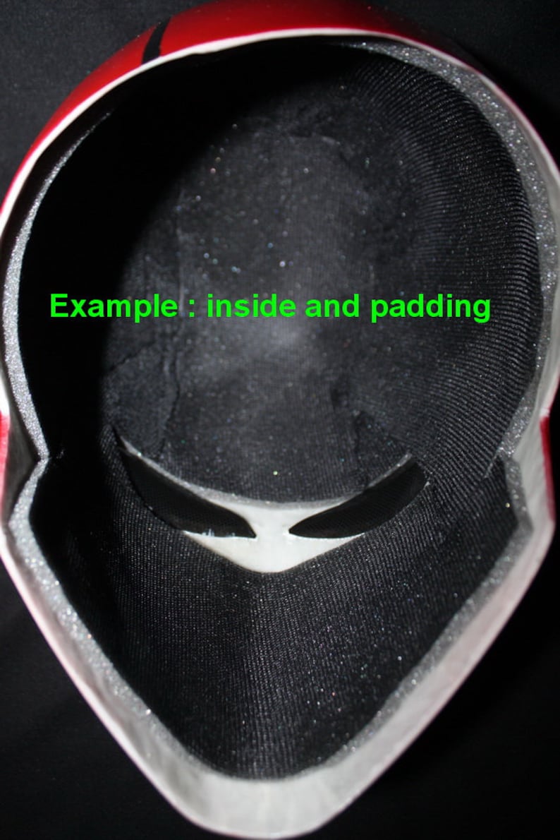 May include: Inside view of a black and red helmet with black padding and a white visor. The text "Example: inside and padding" is visible in the image.