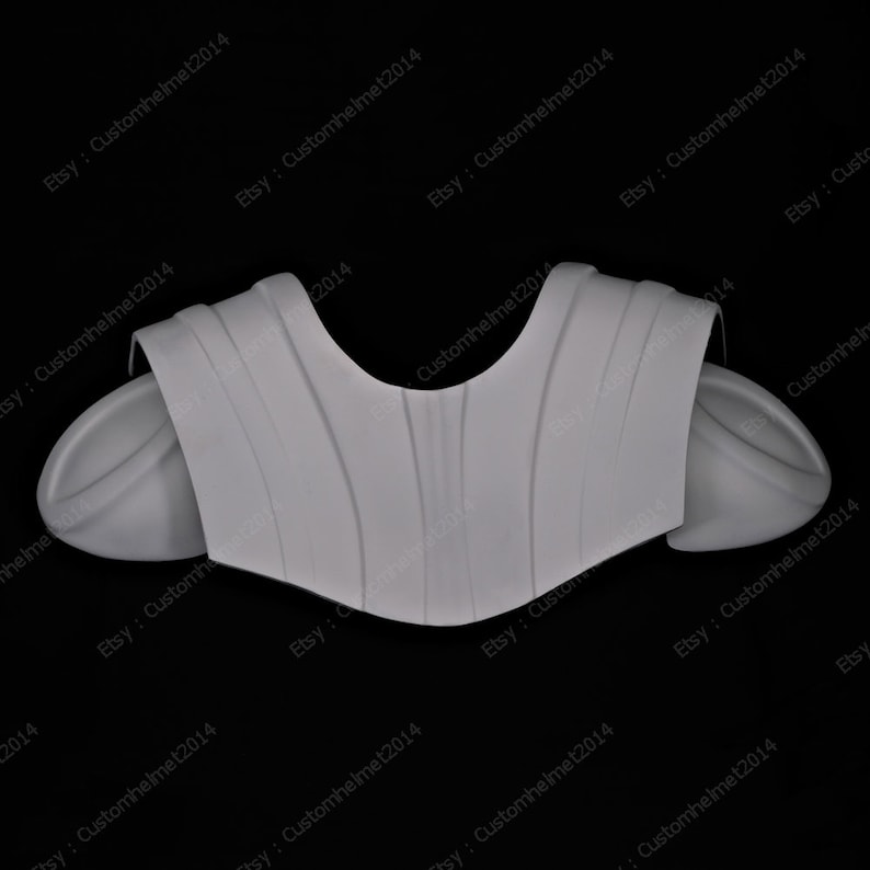 May include: A white plastic molded costume piece for a shoulder armor set. The piece has a textured surface and is designed to fit over the shoulders.