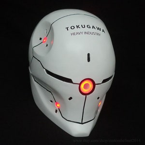 May include: A white helmet with red LED lights and the text "TOKUGAGAWA HEAVY INDUSTRY" on the top.