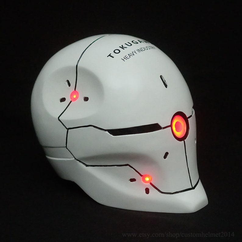May include: White helmet with black detailing and red LED lights. The helmet has the text "TOKU-GAN HEAVY INDUSTRY" on the top.