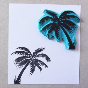 May include: Two palm tree stamps, one blue and one black. The blue stamp is a raised design and the black stamp is a flat design.