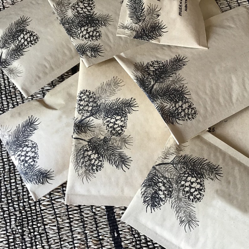 May include: A set of brown paper gift bags with black pine tree illustrations. The bags are decorated with a simple pine tree design and the text "MERRY & BRIGHT".