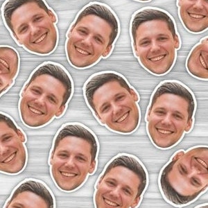 May include: A repeating pattern of smiling faces, each face is a different person, all faces are cropped to show only the head and shoulders, the background is a light wood grain.