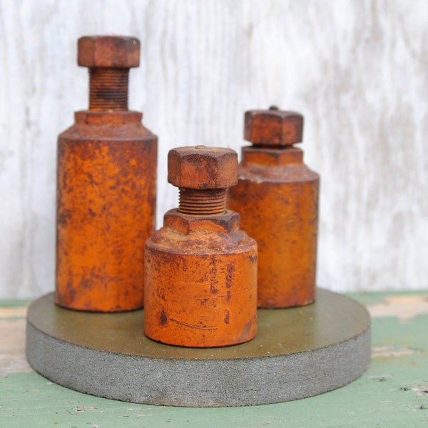 Large, heavy old orange bolt-things -- assemblage of three on grinder wheel