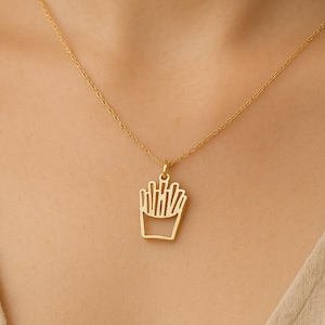 Op de afbeelding: Een gouden ketting met een hanger in de vorm van een doos friet.