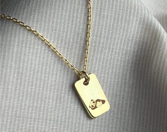 May include: A gold chain necklace with a rectangular pendant featuring a small engraved image of a panda bear.