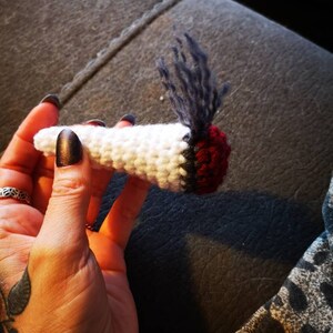 Peut inclure: Un joint crocheté blanc avec un embout rouge et noir et une extrémité floue bleue et grise.