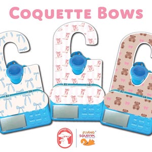 May include: Three blue and white Coquette Bows hair bows with a hanger and a small blue plastic container. The bows have different patterns: blue bows on a white background, pink boots on a white background, and brown teddy bears on a pink background.