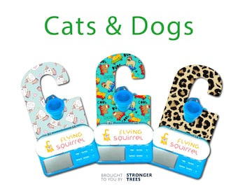 May include: Three pet-themed door hangers with blue accents. One features unicorns, another dogs with skateboards, and the third a leopard print. Each has a blue bucket and the text "FLYING squirrel". The words "Cats & Dogs" are at the top.
