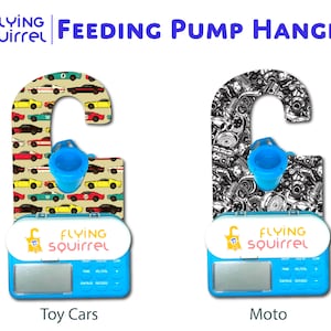 Op de afbeelding: Een blauwe en witte voedingspomp-hanger met een digitaal display en een blauwe tuit. De hanger heeft twee verschillende ontwerpen: een met speelgoedauto's en de andere met motorfietsen. De tekst "Flying Squirrel" staat op de voorkant van de hanger.
